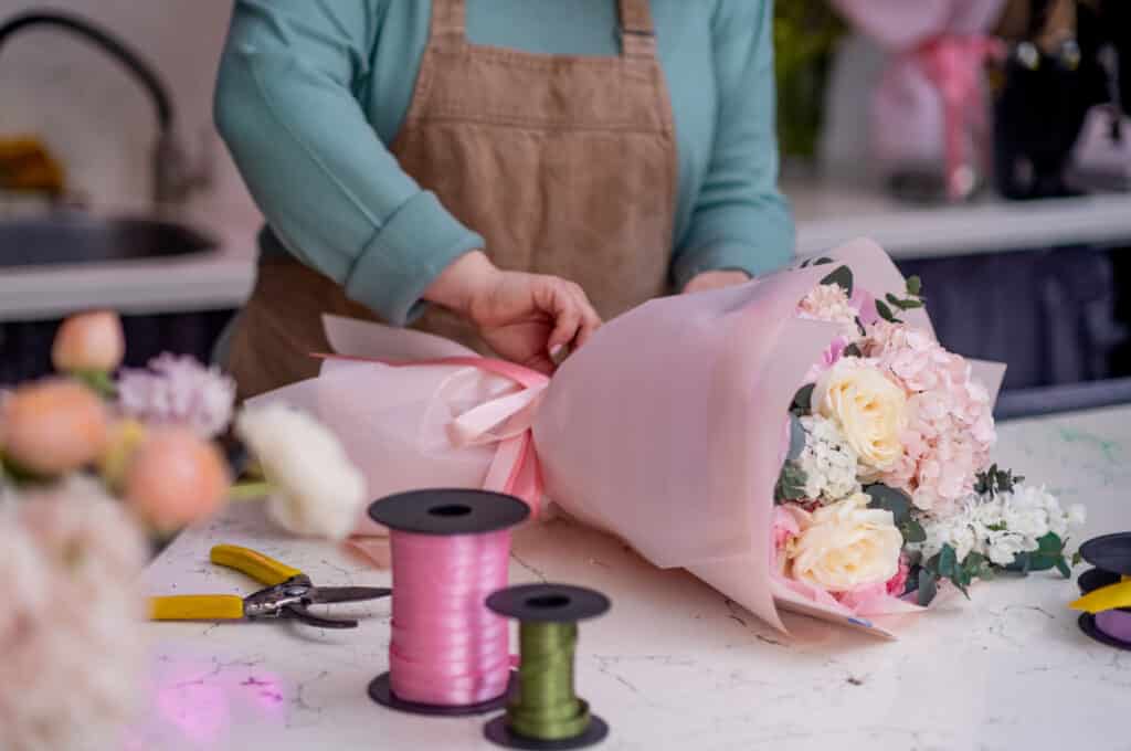 woman florist makes floral design for wedding, decorator preparing flower for birthdays and parties.