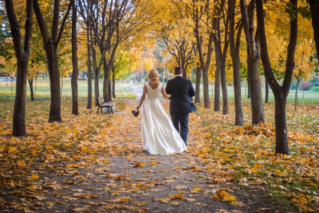 Mariés marchant dans parc automnal